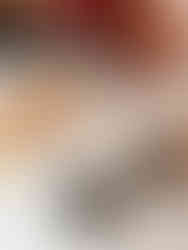 Detailaufnahme einer Hochzeitstorte mit dunkler Glasur, dekoriert mit Perlen und Beeren