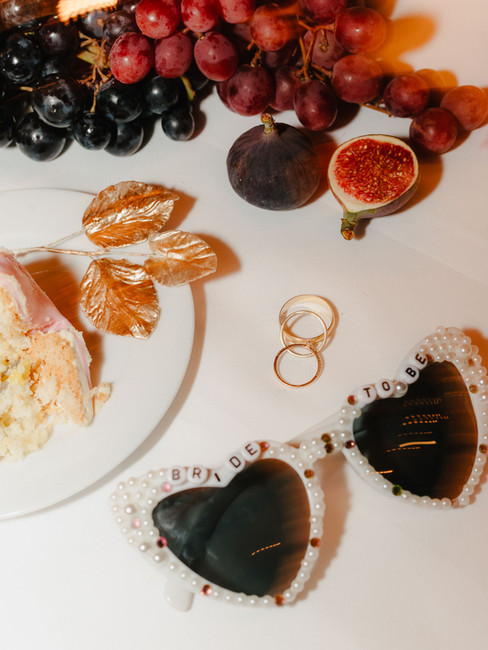 Detailaufnahme einer Hochzeitstorte mit dunkler Glasur, dekoriert mit Perlen und Beeren