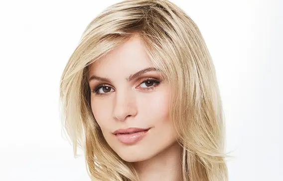 Modella che indossa una parrucca in capelli veri lunghi di qualità superiore, soluzione invisibile per diradamento o cambio look disponibile a Udine e Portogruaro.