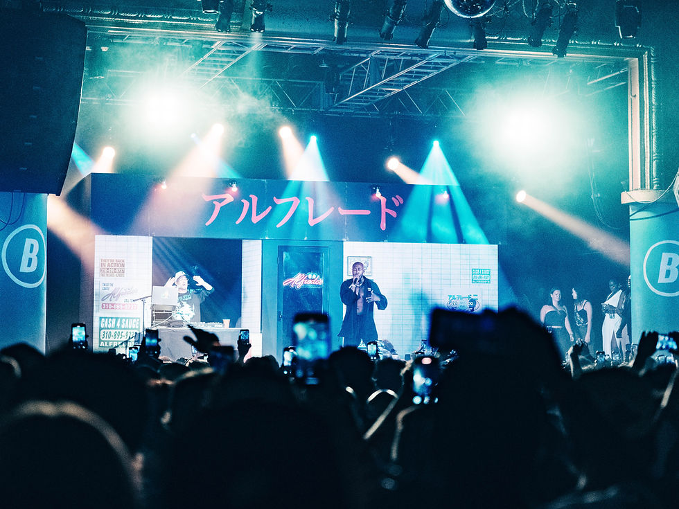 Freddie Gibbs energizes the crowd on stage at The Beacham, surrounded by vibrant lights and a dynamic set design. Photo taken by Marcia Zeledon