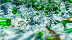 Pile of clear and green glass bottles.
