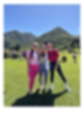 Chicas de rosado posando juntas, atras un montaña