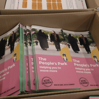 Box of colorful brochures titled "The People's Park: Helping you to move more," featuring diverse people walking. Promotes Active Calderdale.