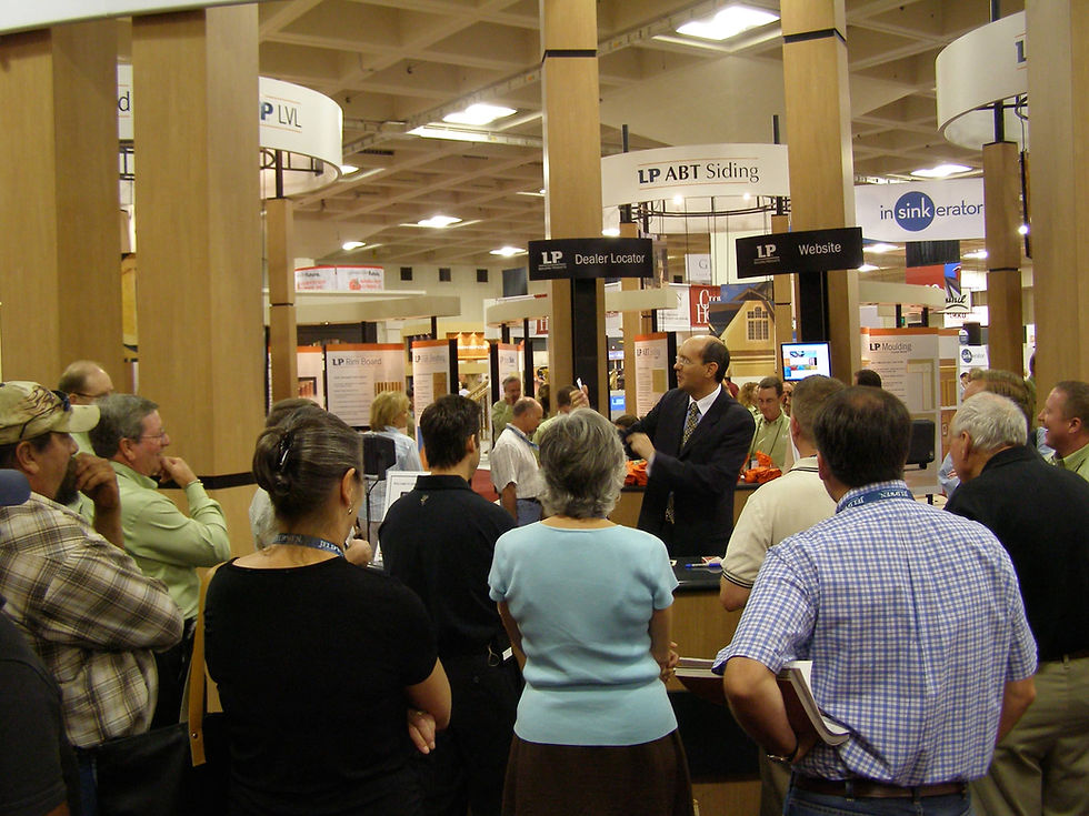 Lee Lentz presenting to an engaged crowd at the LP Building Products booth during the 2004 Pacific Coast Builders Conference (PCBC), with LP ABT Siding and other LP product displays visible.