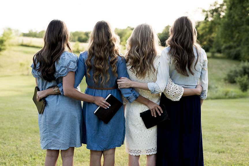 beautiful-shot-four-girls-with-their-arms-around-each-other-while-holding-bible.jpg