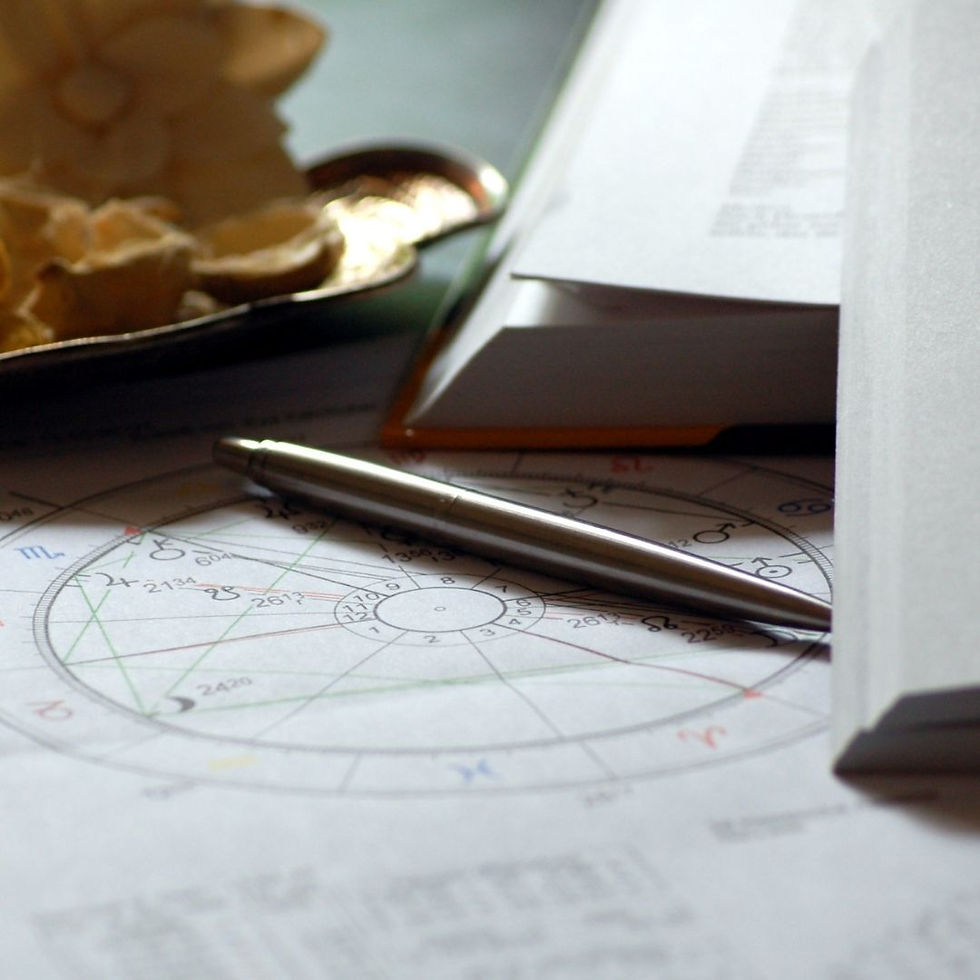 ein Stift liegt auf einem Blatt auf dem ein Geburtshoroskop aufgezeichnet ist