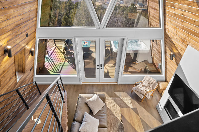 Upward view of living room interior in a luxury cabin near Zion National Park featuring large windows and wood-accented architecture in Southern Utah.