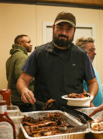 Man serving breakfast at a community event livestream.