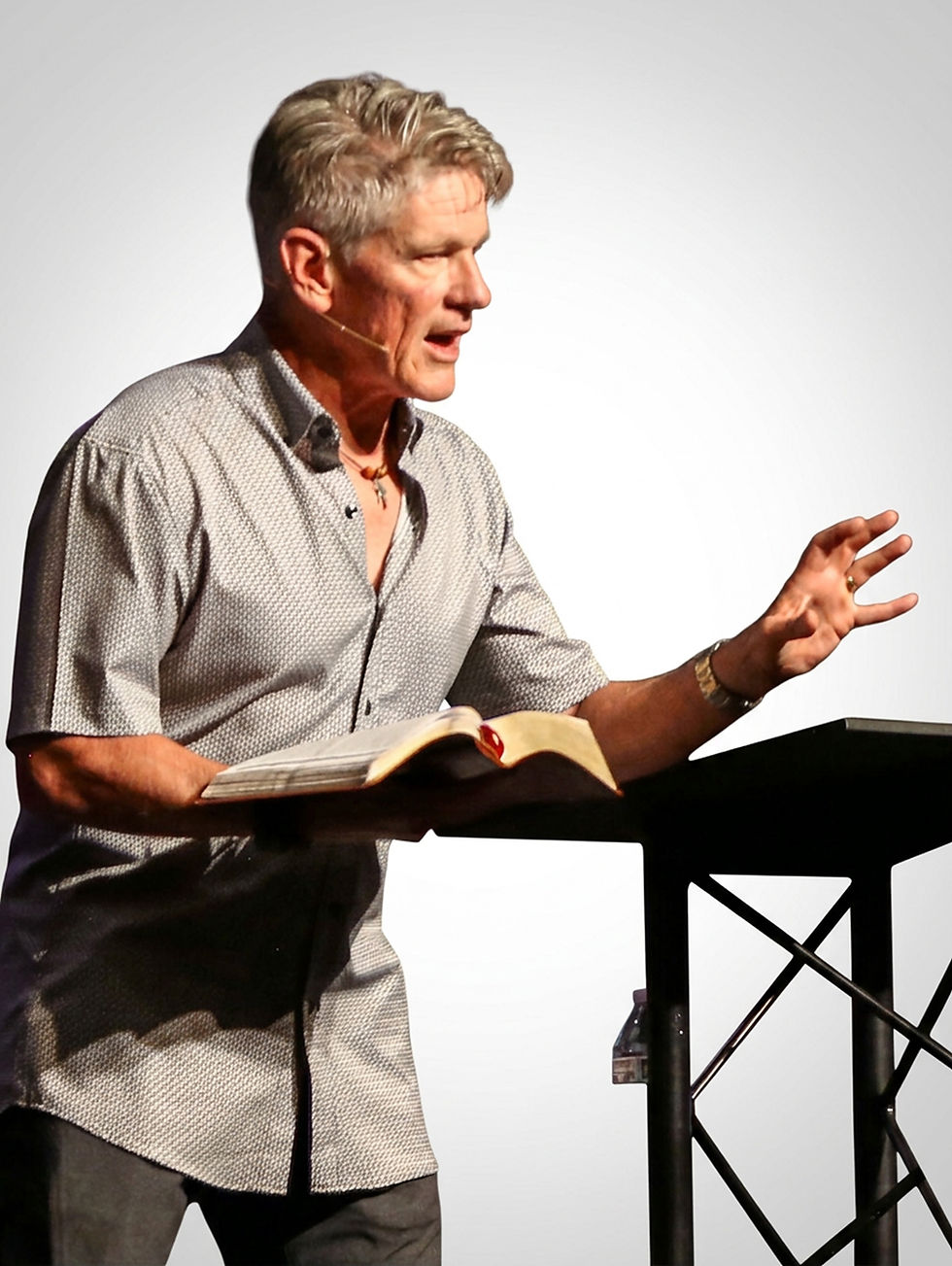 Pastor preaching with an open Bible at a pulpit
