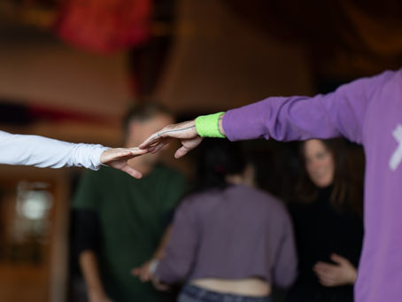 Contact Improv dancers with outstretched arms touching at Seattle Ecstatica