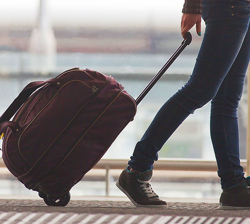 Person Rolling Suitcase in Airport