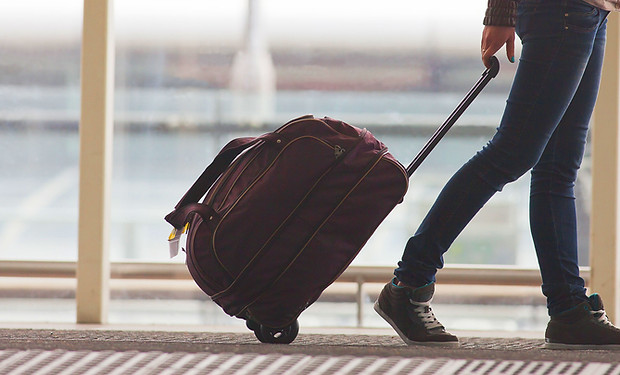 Persona di rotolamento valigia in aeropo