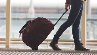 Person Rolling Suitcase in Airport