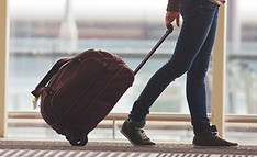 Person Rolling Suitcase in Airport