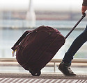 Person Rolling Suitcase in Airport