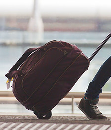 Person Rolling Suitcase in Airport