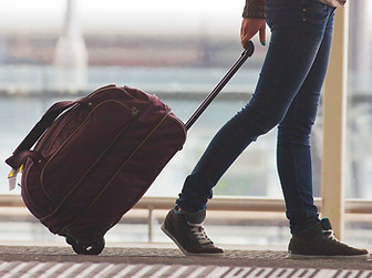Person Rolling Suitcase in Airport