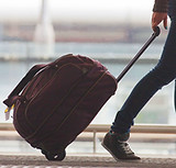 Person Rolling Suitcase in Airport