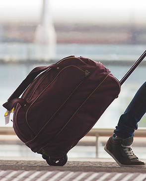 Person Rolling Suitcase in Airport