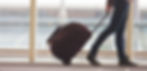 Person Rolling Suitcase in Airport