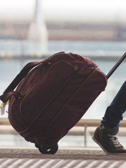 Person Rolling Suitcase in Airport
