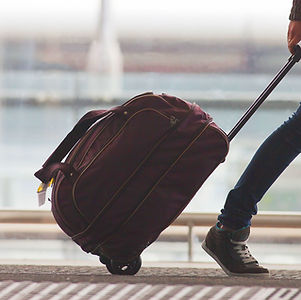 Person Rolling Suitcase in Airport