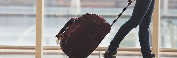 Person Rolling Suitcase in Airport