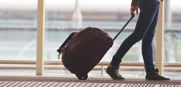 Persona di rotolamento valigia in aeroporto