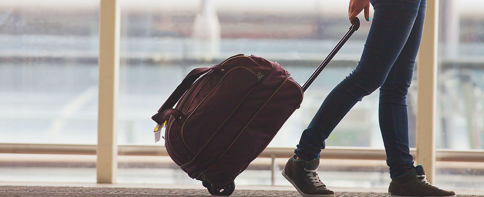 Person Rolling Suitcase in Airport