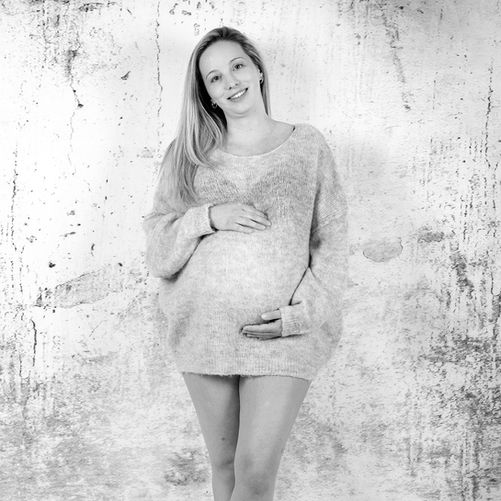 Elegantes Porträt einer schwangeren Frau im Studio – zeitlose Schwangerschaftsfotografie mit sanftem Licht.