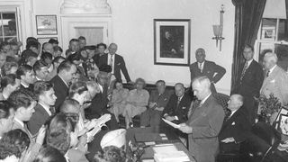 President Truman reads the announcement of Japanese surrender in the Oval Office, August 14, 1945, photo by Abbie Rowe, National Park Service, Harry S. Truman Library