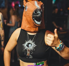 A person wearing a plastic horse head mask in One Eyed Willy's Swansea. They're holding up their hands doing a thumbs up. 