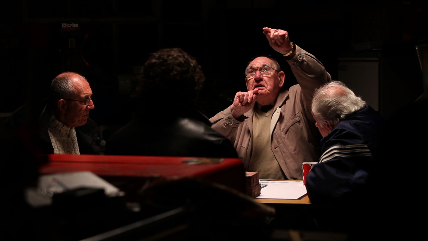 Bob Fulton, a Scottish man in his 90s recalls their action of solidarity for Chile around a dimly lit table, surrounded by John Keenan and Robert Somerville