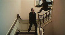 Dark Angels (1998) movie still - martial artist superhero jumps off top of stairs to administer a flying kung fu kick to his opponent