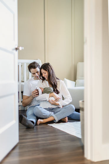 Nouveau parent assis dans la chambre de bébé avec bébé dans les bras