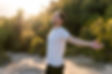 An attractive man breathes fresh air from nature at sunset. Healthy lifestyle and emotiona