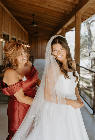 Mother helping the bride into her wedding dress before the ceremony at The Chandelier of Gruene.