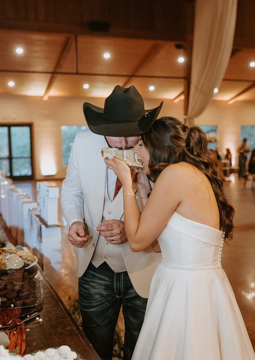Bride and groom sharing wedding cake together during the reception at The Chandelier of Gruene.