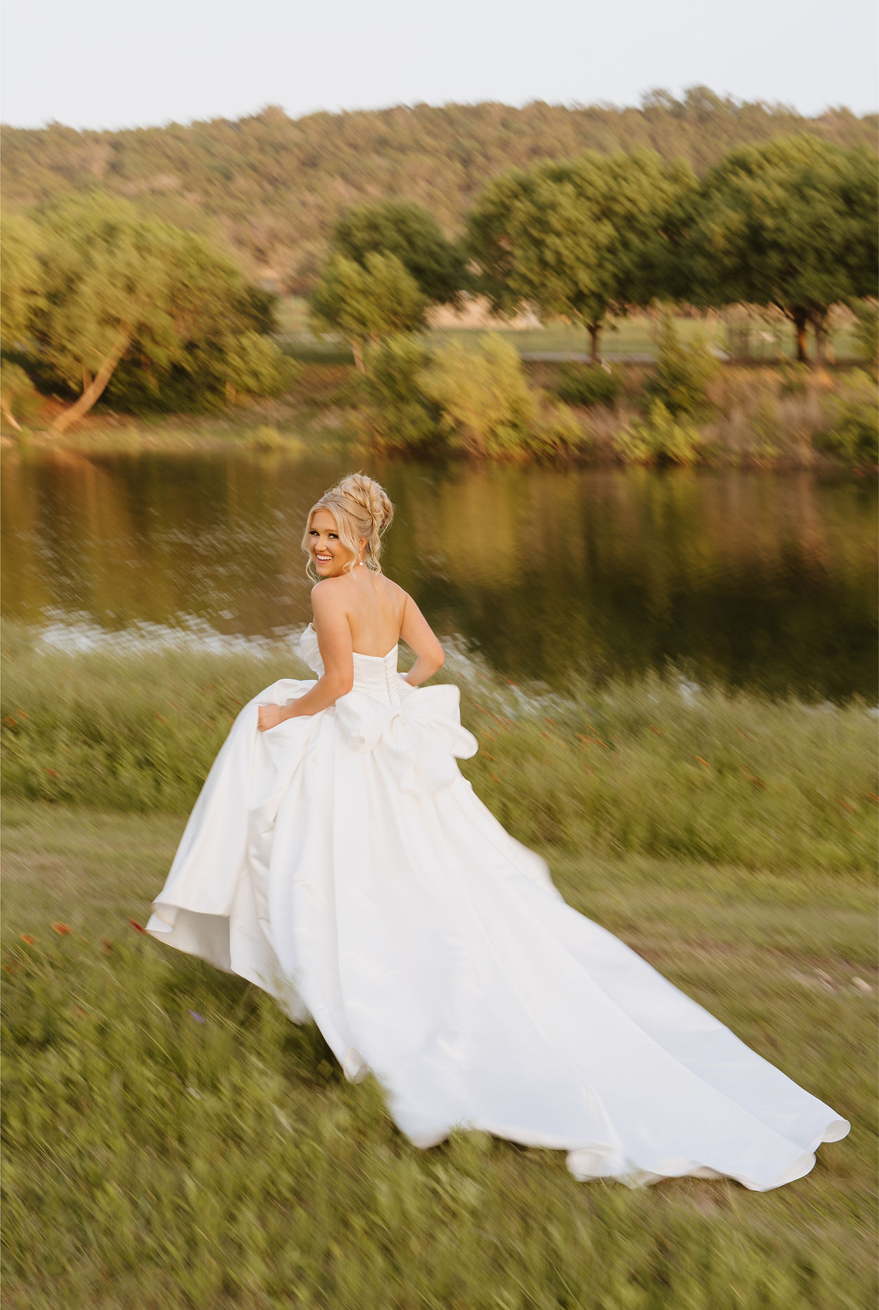 Bride walking and smiling during outdoor portraits at Sendera Springs near Fredericksburg