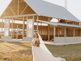 Wide bridal portrait in front of The Allen Farmhaus chapel in New Braunfels.