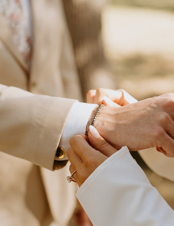 Close-up of the bride fastening a bracelet on her groom during their wedding at The Addison Grove in Dripping Springs, Texas, photographed by Grace J Photo, a Dripping Springs wedding photographer capturing heartfelt Hill Country celebrations.