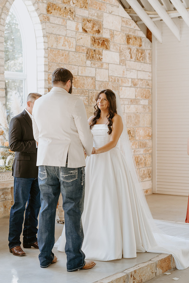 Bride and groom standing together at the altar during their wedding ceremony at The Chandelier of Gruene in Gruene, Texas.