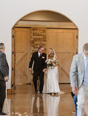Bride walking down the aisle with her father during indoor ceremony at Canyonwood Ridge Dripping Springs wedding