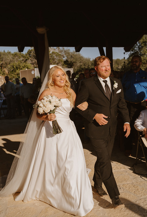 Bride walking down the aisle during her ceremony at a private ranch wedding in the Texas Hill Country, Texas