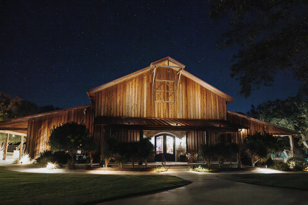 Moody nighttime view of the barn beneath the Texas stars at The Chandelier of Gruene.