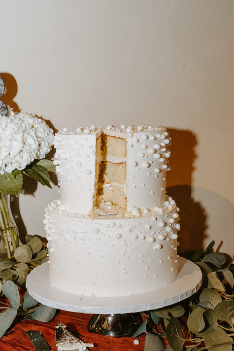Elegant wedding cake displayed during the reception at The Chandelier of Gruene.