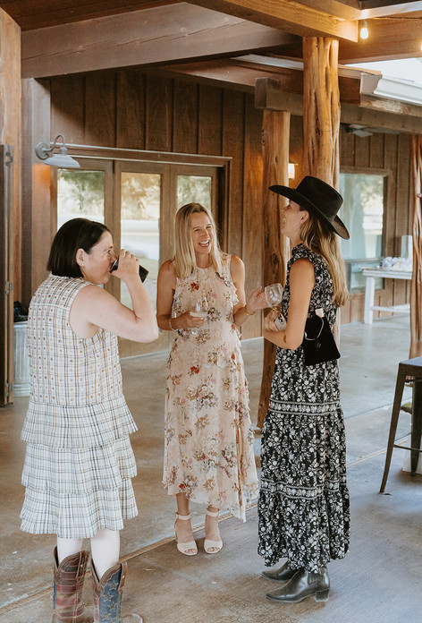 Wedding guests talking and laughing together during the reception at The Waters Point in Wimberley, Texas
