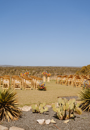 Wide shot of ceremony decor with Hill Country hills in the background at Walden Retreats in Johnson City, Texas wedding