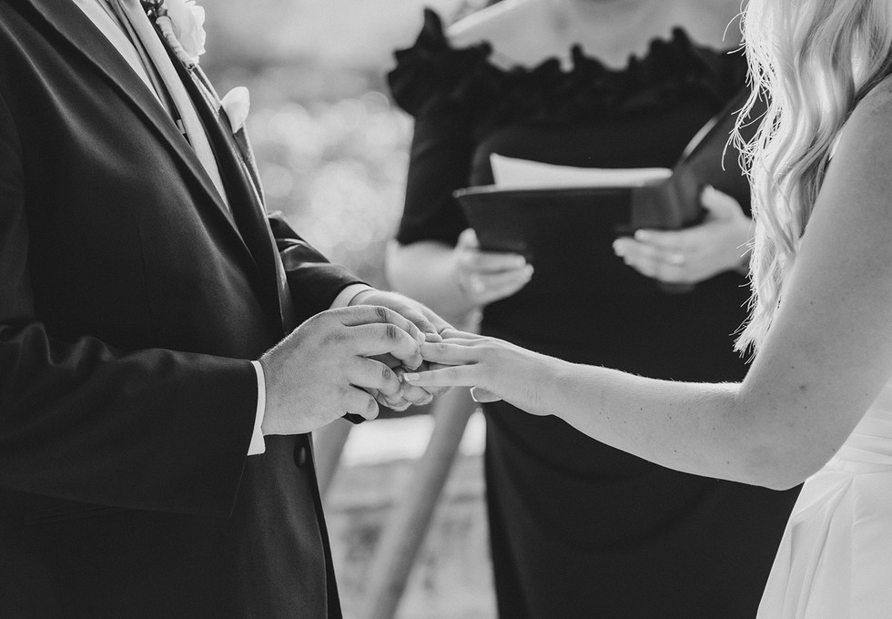 Close up of the bride and groom placing wedding rings on each other during their ceremony at a private ranch wedding in the Texas Hill Country, Texas