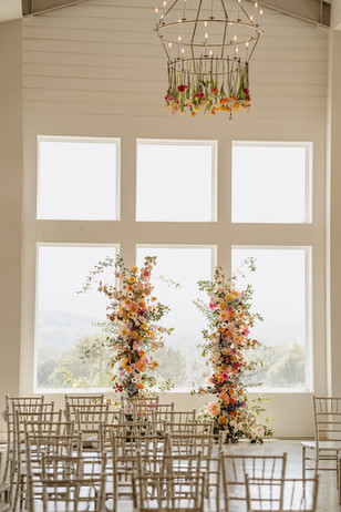 Wide shot of indoor ceremony space with lush florals at Camp Hideaway in Fredericksburg, Texas Hill Country wedding